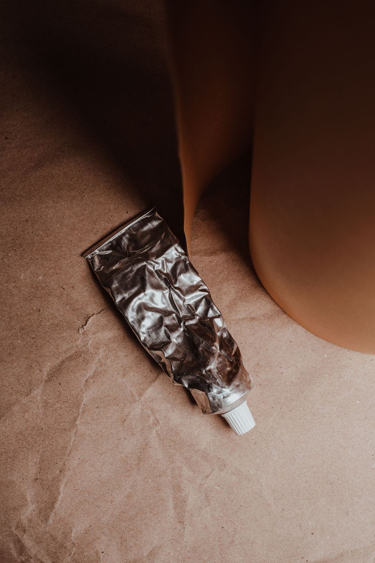 A cream tube on brown paper
